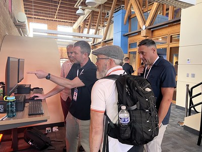 People discussing at computer demo station