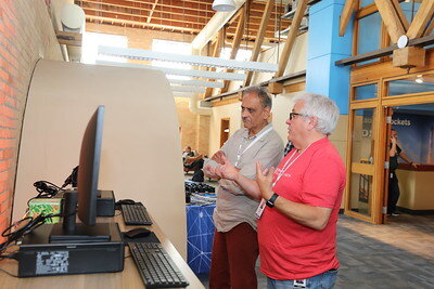 People discussing at computer demo station