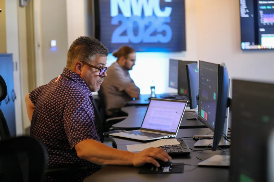 Person sitting at a work station with laptop.